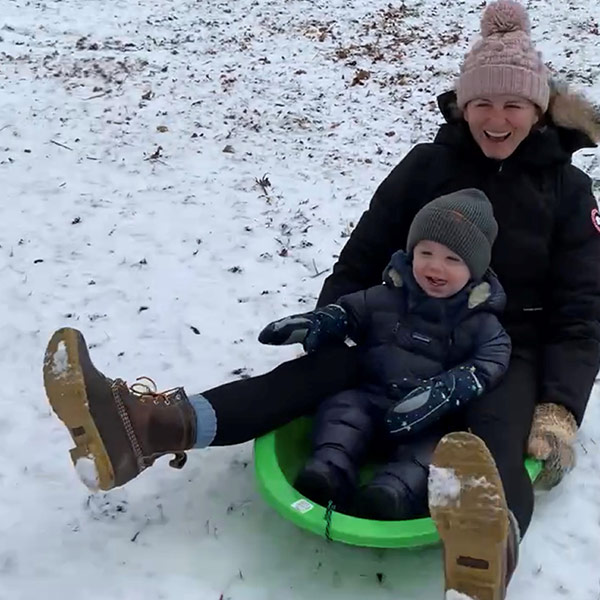 A mother and son sledding on the snow