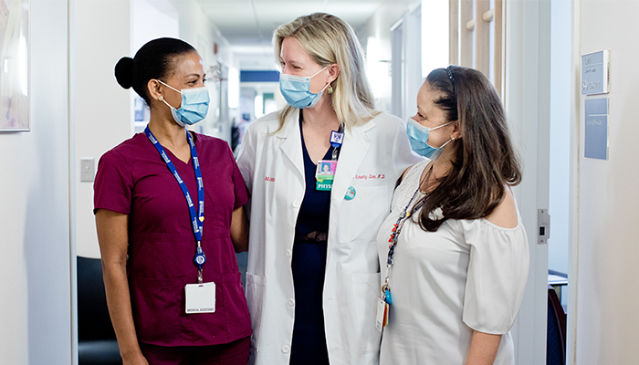 three female women's health providers in hallway