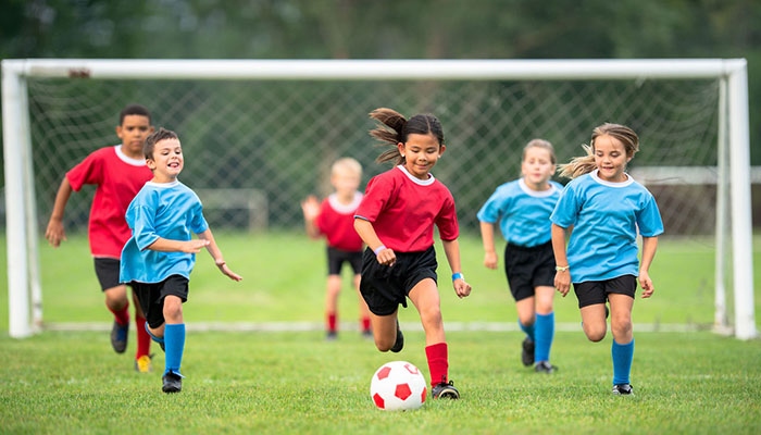 Kids running on a soccer field