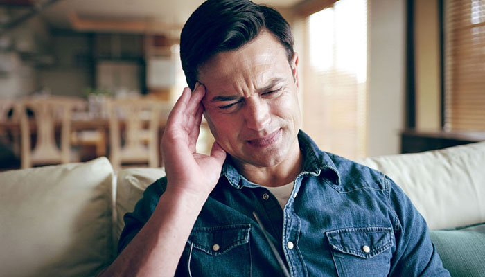 Man clutching his head in pain
