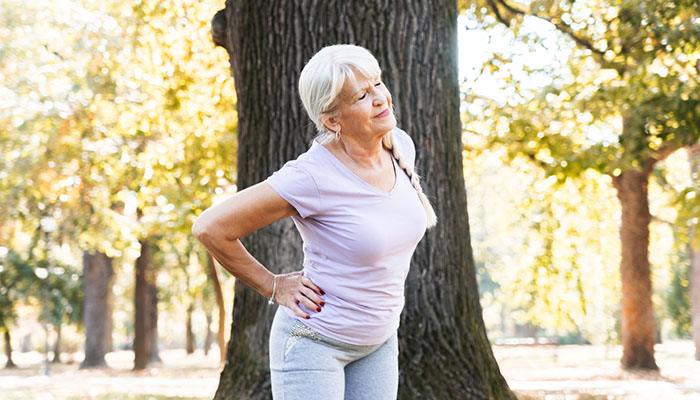 Senior woman stretching in a park.