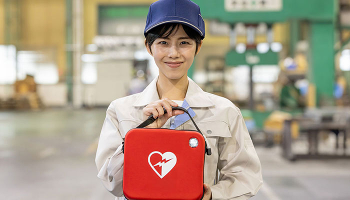 Woman holding an AED pack.