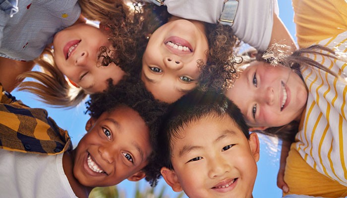 A diverse group of children smiling into a camera