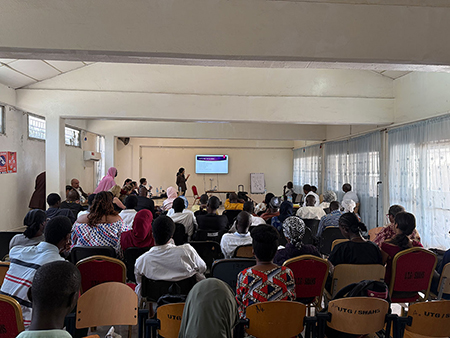 A group watches a research presentation in The Gambia