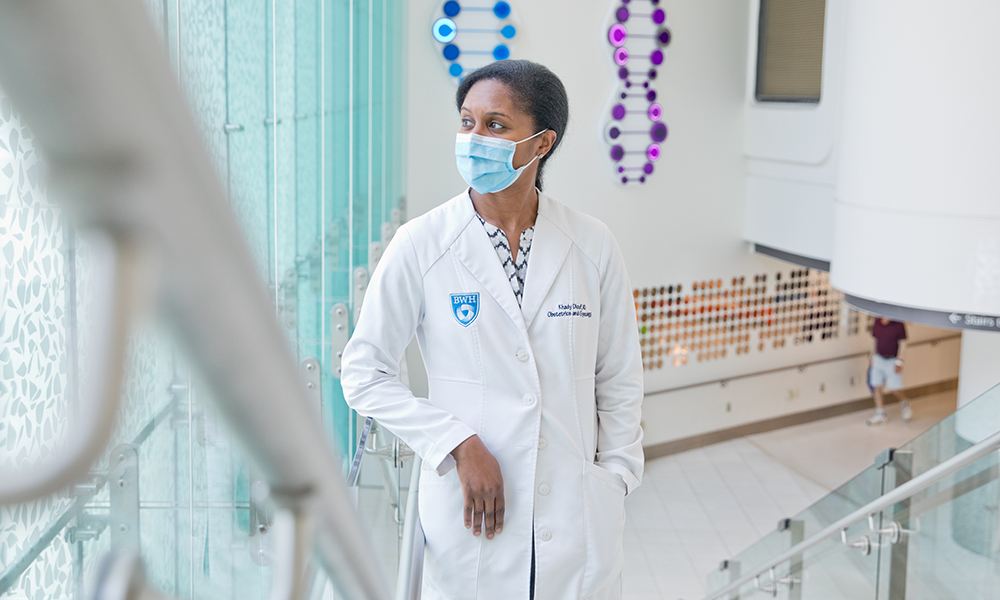 female doctor on staircase looking out window