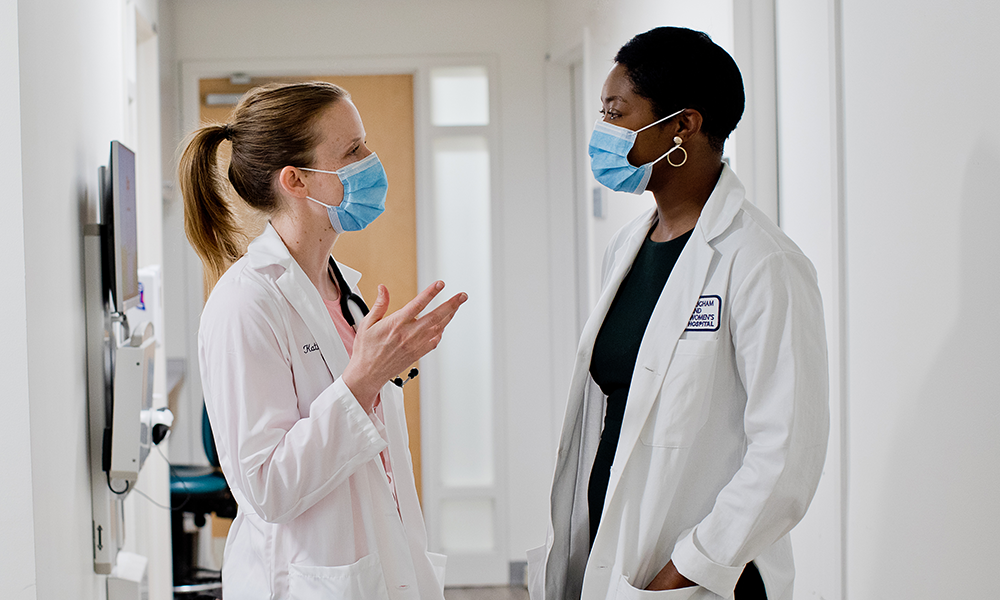 two female team members chatting in hallway