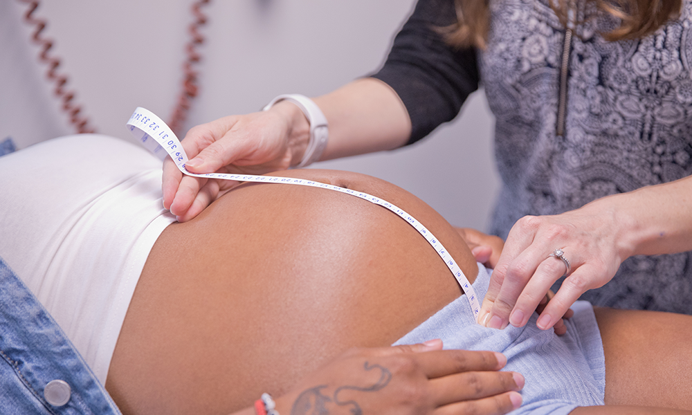 clinician measuring stomach of pregnant mother