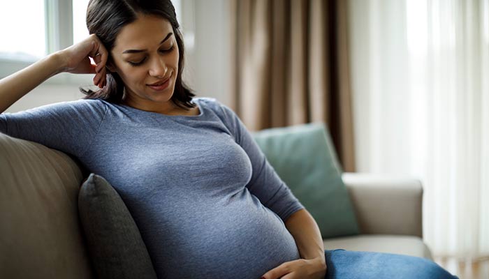 Woman looking at her pregnant stomach