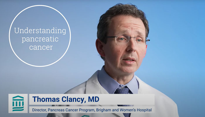 Physician speaking in front of backdrop