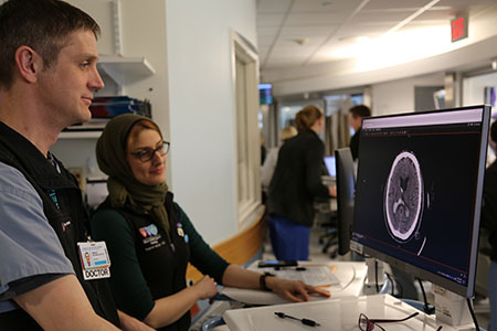 neurocritical care staff looking at computer monitor
