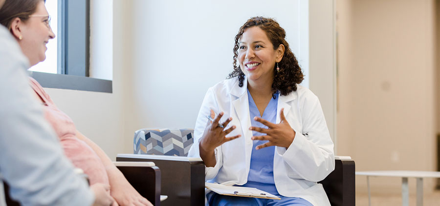 Ob Gyn provider sitting across from a patient while talking