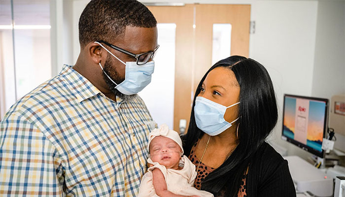 Kenyatta Coleman in the Brigham NICU with husband Derek Coleman and daughter, Denver.